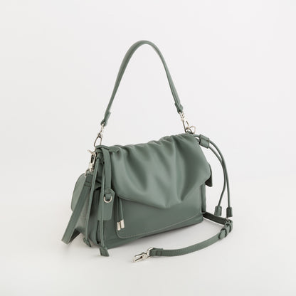 A sage green leather shoulder bag with a slouchy top, a front flap pocket, and a detachable shoulder strap, shown on a clean white background.