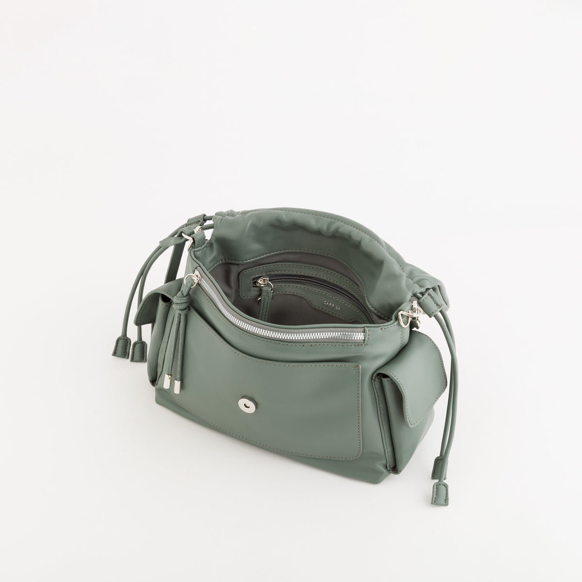 A sage green leather shoulder bag with a zippered main compartment, a front slip pocket, and drawstring details, shown from an overhead angle on a white background.